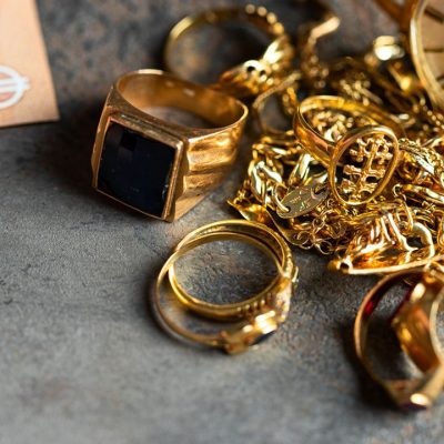 Old and broken jewelry  and on Euro banknotes on dark background. Sell gold for money  concept.